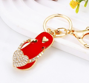 Macro shot of red rhinestone-studded flip-flop keychain with large crystal heart detail