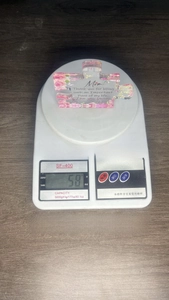 Macro shot of puzzle-shaped acrylic plaque showing dimensions 10x8.5x1cm on weighing scale