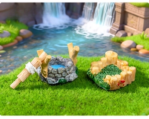 Detailed view of resin miniature well and wooden fence ornaments for fairy gardens