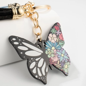 Colorful butterfly keychain with black floral patterns, gold chain, and black tassel detail
