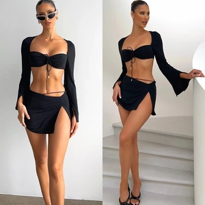 Three-piece black set featuring cropped top, long sleeve bolero, and side slit mini skirt