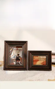 Close-up of vintage walnut wood frames with gold studded relief on elegant lace tablecloth