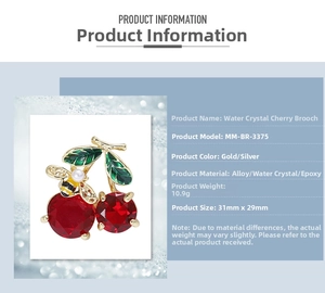 Detail view of crystal cherry brooch with red rhinestones, green leaves and a small bee