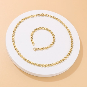 Minimalistisches Set aus goldener Edelstahl-Halskette und Armband auf Display