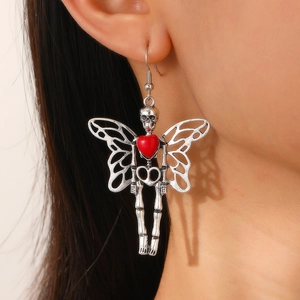 Macro view of gothic silver butterfly earrings with a red heart-shaped skull drop detail
