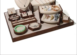 Detailed set of walnut wood and beige microfiber jewelry stands for various accessories