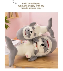 Detail of plush shark-dog hybrid toys in two sizes on a cozy wooden table background