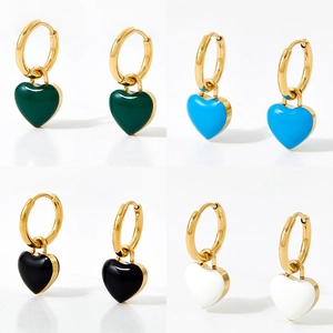 Golden heart earrings set with black and colorful enamel pendants on white background