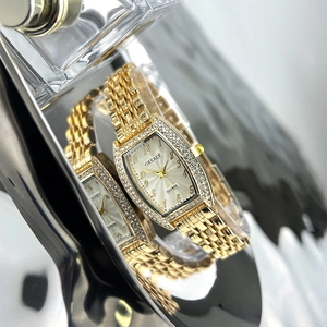 Detailed view of tonneau emerald gold quartz watch dial with diamond-encrusted bezel