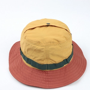 Detail of color-block outdoor bucket hat with ginger top and red brim