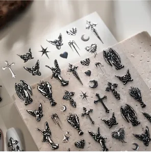 Macro view of Gothic nail art stickers featuring 3D silver and black metal cross patterns