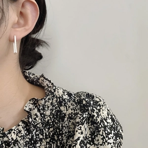 Close-up of minimalist S925 sterling silver geometric rectangular earrings on model