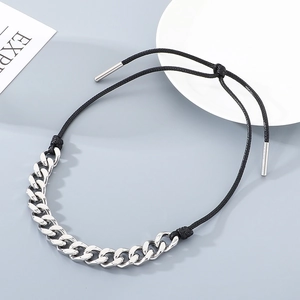 Detailed view of silver stainless steel Cuban chain spliced with black braided rope necklace