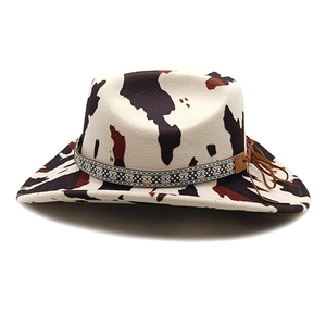 Western cowboy hat with cow print pattern and braided band with tassel details