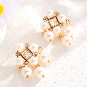 Detail of vintage French gold earrings with layered pearls and square crystal on stone