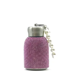 Close-up of 300ml pink rhinestone water bottle with stainless lid and pearl handle strap