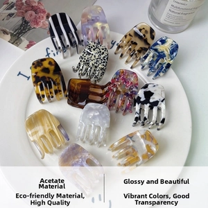 Detailed close-up of premium acetate hair claws with elegant tortoise shell and floral patterns