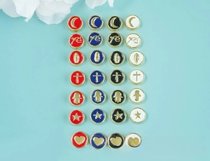 Detailed flat lay of colorful enamel charms with religious and celestial gold-plated motifs