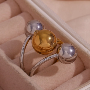 Macro shot of 18K gold and silver plated adjustable rings with triple bead design
