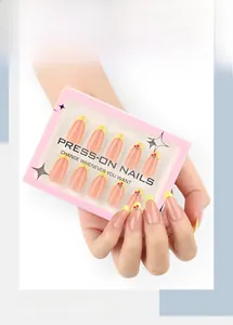 Detail of 3D cherry almond press-on nails with yellow French tips on a nude pink base
