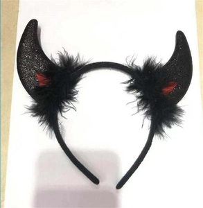 Close-up of black glittery devil horn headband with red inner ears and feather trim