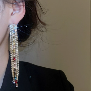 Macro shot of elegant long tassel earrings with multicolored zircon stones and silver needles