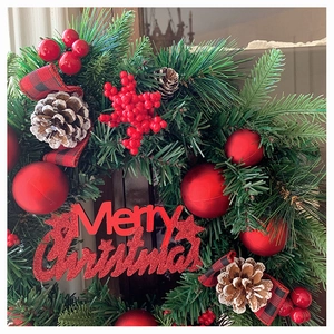 Detail von Weihnachtskranz mit roten Beeren, Zapfen und Merry Christmas Schild