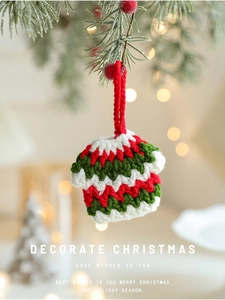 Miniature handmade crochet Christmas sweater ornament hanging on tree with bokeh lights