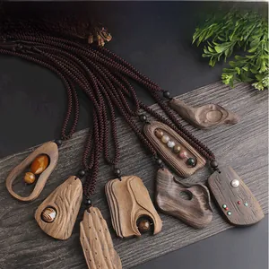 Detailed view of handmade dark wood pendants with inlaid stones and woven cords