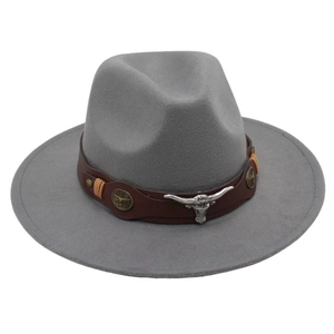 Detail of grey felt cowboy hat featuring leather band with bull skull and metal badges