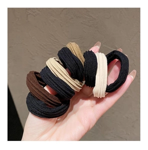 Close-up of high-elasticity ribbed hair ties in earthy tones held in hand for detail