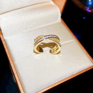 Macro shot of gold-plated criss-cross ring with pavé zircons in a premium jewelry box