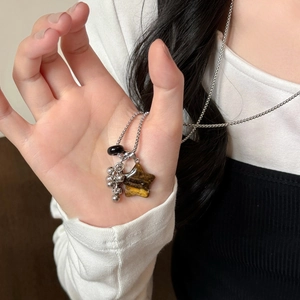 Detailed close-up of tiger eye star pendant and silver beaded fringe on a metal necklace