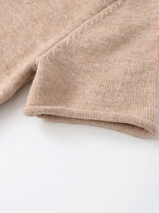 Detail shot of camel knit sweater showing soft ribbed texture and seamless rolled edges