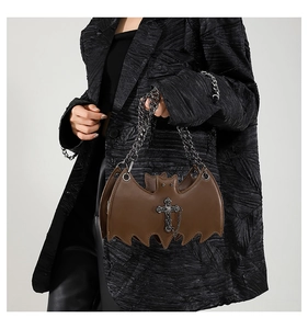 Close-up of gothic brown bat-shaped purse with vintage metal cross and chain strap