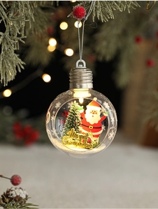 Macro view of light bulb Christmas ornament with Santa Claus and festive interior scenery