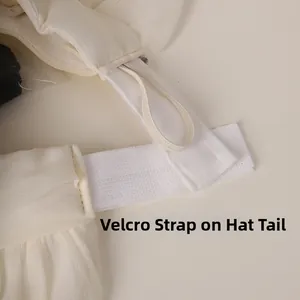 Detail of adjustable velcro closure on white mesh sun hat for flexible head sizing