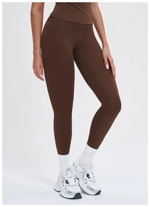 Detail of high-waist yoga pants in brown with seamless stitching and matte finish