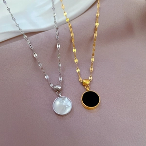 Doppelseitige Muschel-Halsketten in Gold und Silber auf einem weichen Stoffhintergrund