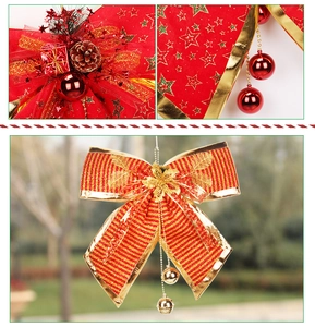 Detail of red Christmas bow with pine cones, gift boxes and bells on striped fabric