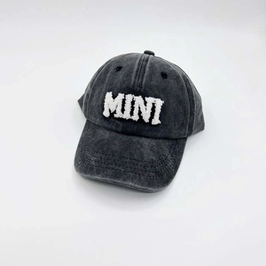 Detail of white chenille MINI embroidery on a vintage washed dark grey baseball cap