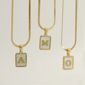 Detail of square shell initial pendants A, M, O on golden flat snake chain necklaces