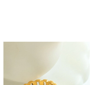 Macro shot of gold geometric ring featuring unique wavy textures and multi-layered design