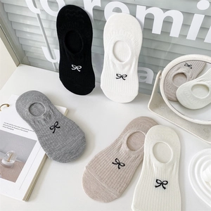 Detail of five pairs of cotton low-cut socks with bow embroidery in various neutral colors