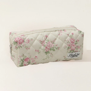 Close-up of quilted floral beige pencil case with pink flower patterns and zipper detail
