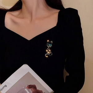Detailed view of an elegant fox brooch with navy crystals on a black dress lapel