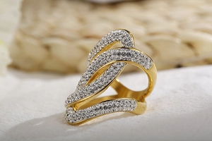 Detailed close-up of a gold-plated chunky ring with pave-set rhinestones and wave design