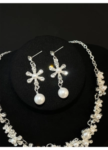 Detail of luxury flower necklace and earrings set with silver plating and white pearls