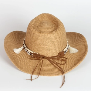 Detail view of woven straw cowboy hat with bohemian shell and fringe decorative band