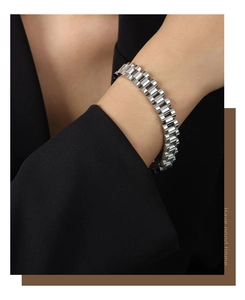 Macro view of silver chain-link bracelet showing detailed metal texture on a wrist